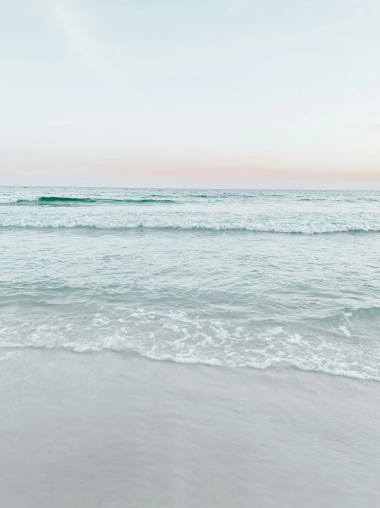 a picture of the ocean and sand with waves