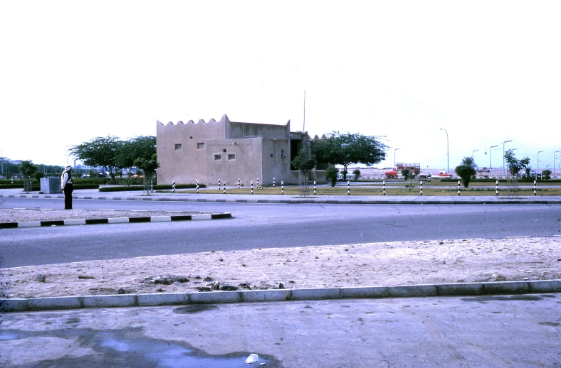 a building sitting on top of a field near a street