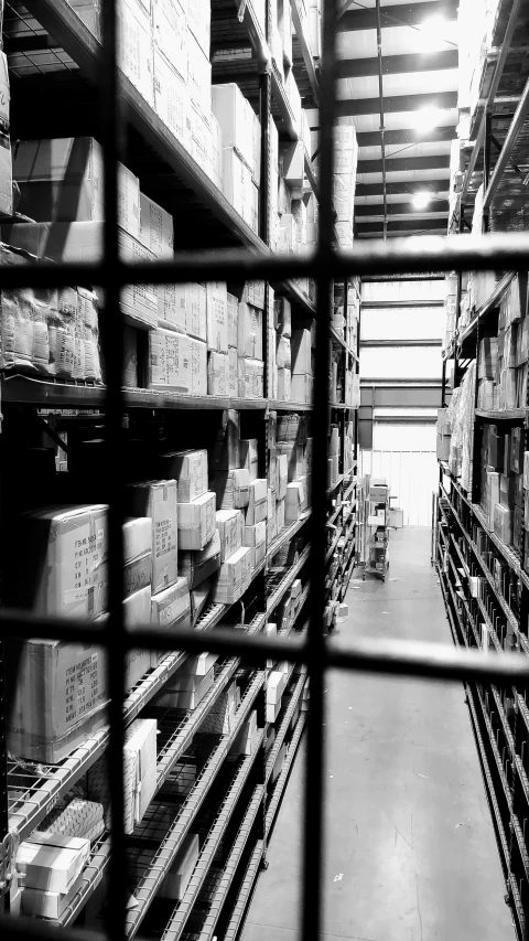 a black and white po of stacks of boxes in a warehouse