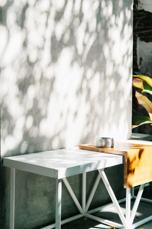 a wooden table and a metal planter on a sunny day