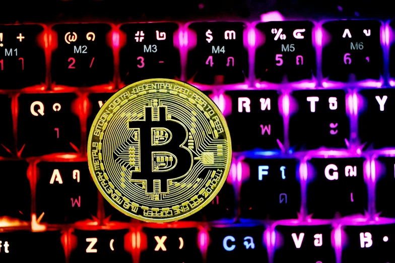 a golden bitcoin sitting on a keyboard