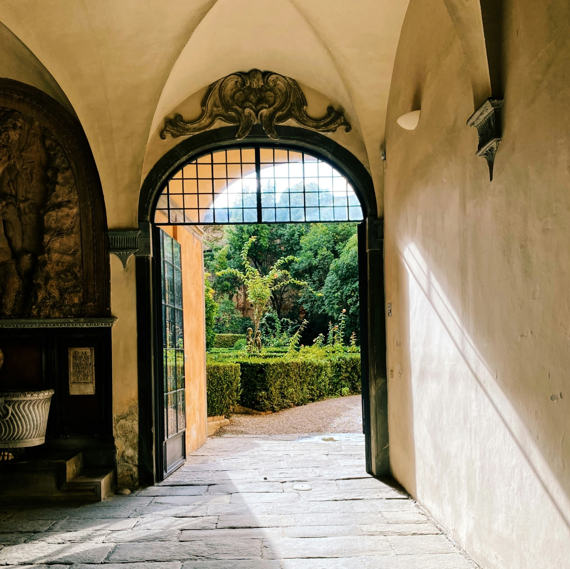 an open arched doorway leads into a lush garden