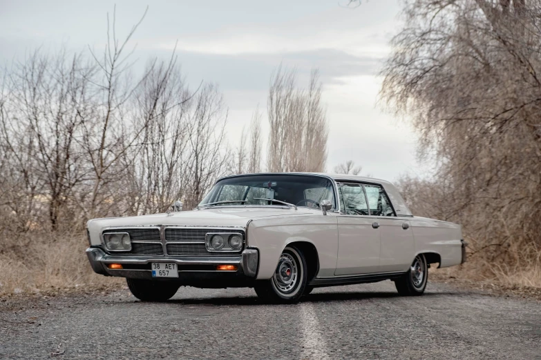 a white classic car on a rural road