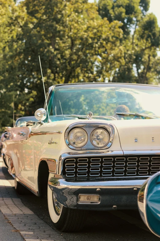 an old classic car is sitting on the side of the road