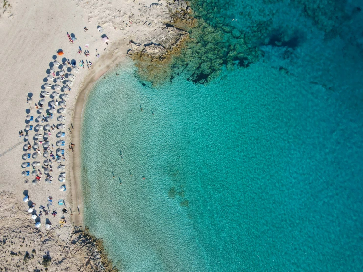 people are standing on the sand at a beach