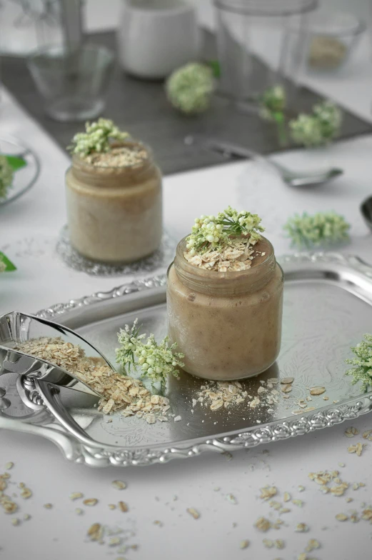 two desserts sit on a silver tray with spoons