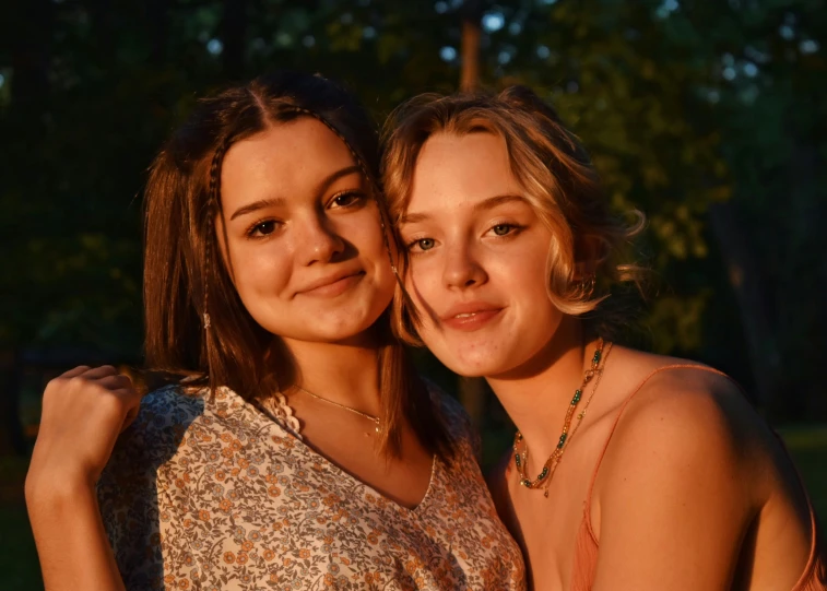 two women in white and brown posing for the camera