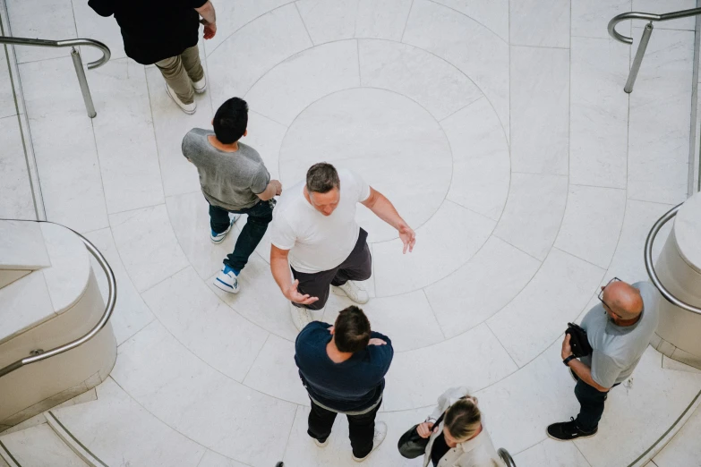 a group of people standing around an escalator