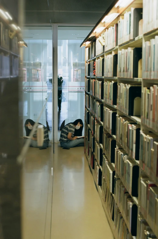 two people laying in the liry while they are reading