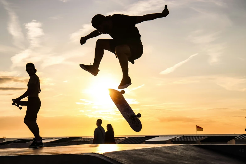 the man on the skateboard is doing tricks in front of the sun