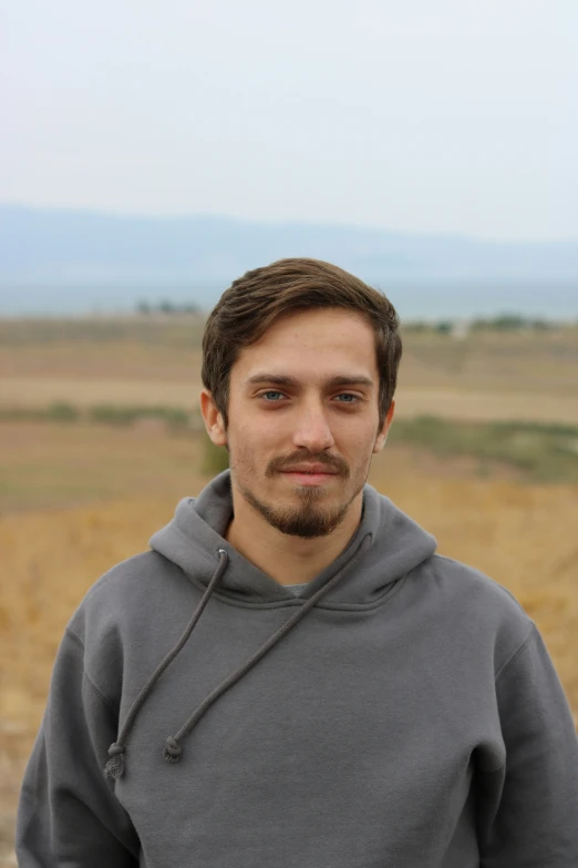 a man with a beard wearing a gray sweater