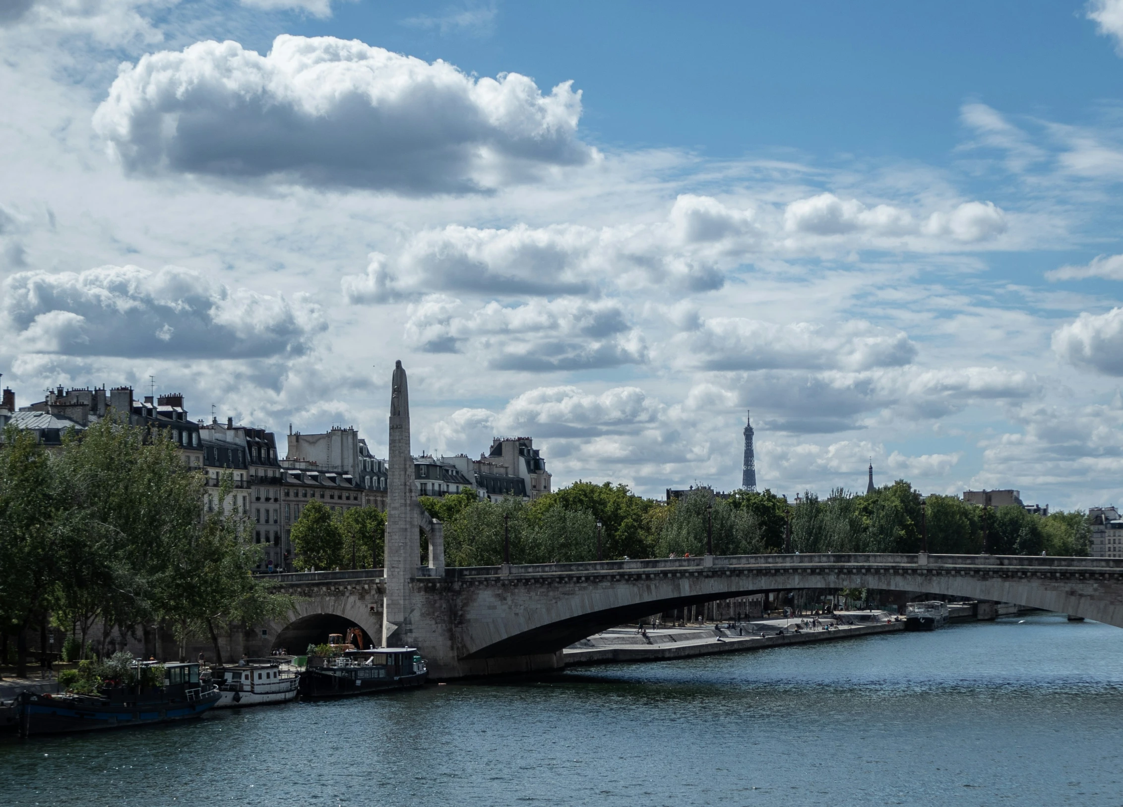 a bridge going over a body of water with buildings in the background