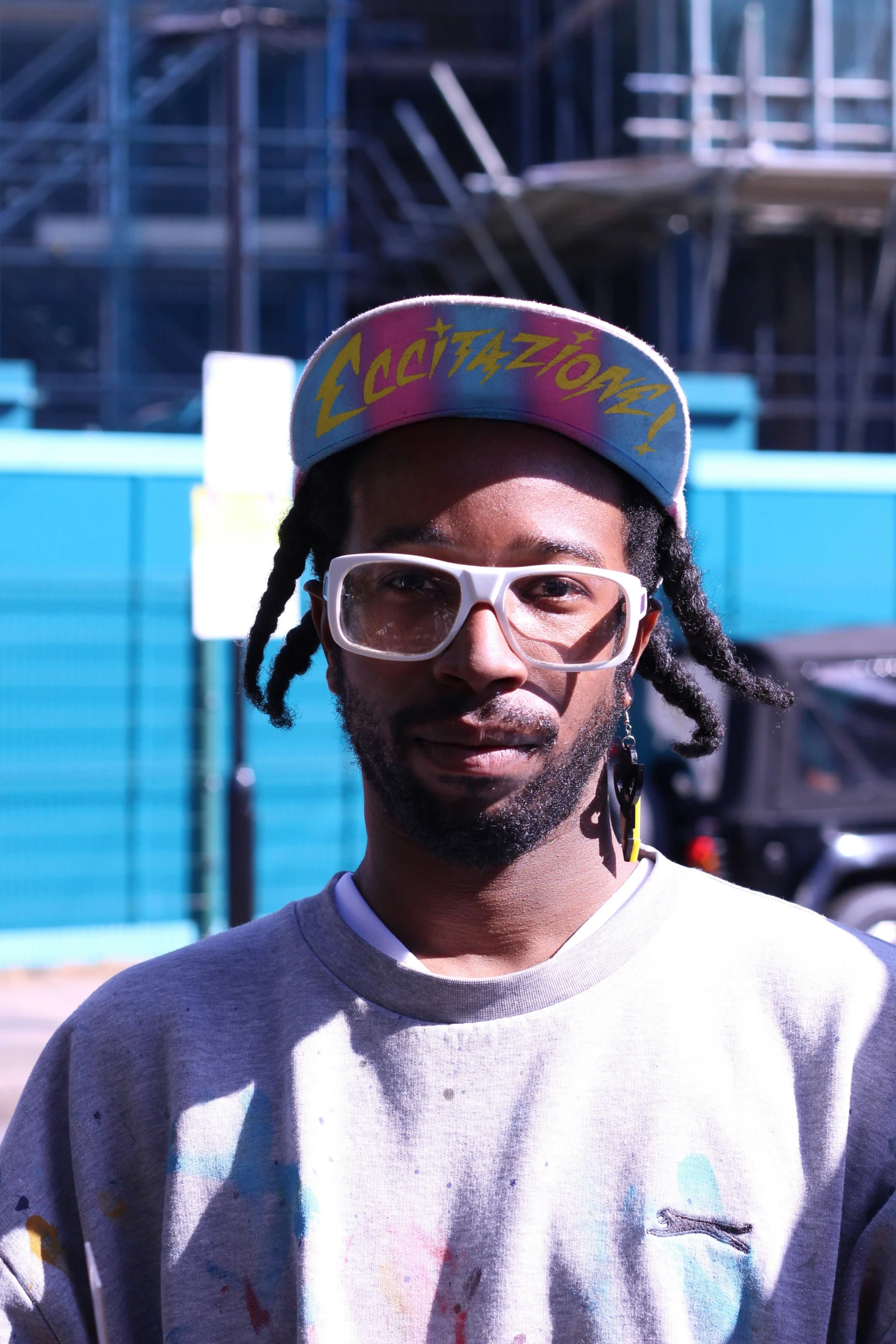 a man wearing white glasses and a hat