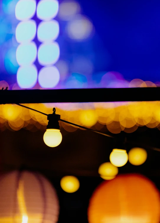 a street light hanging from a beam in the middle of a dark area