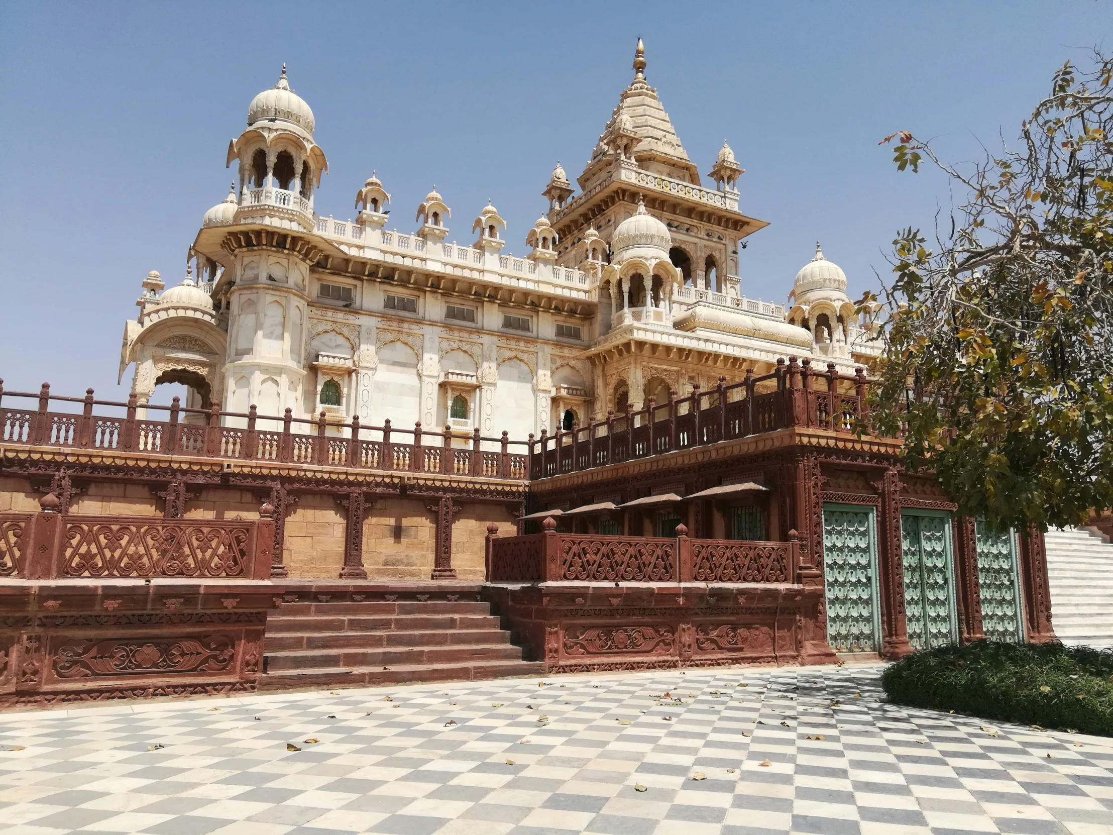 a house with multiple floors and turrets in a small courtyard