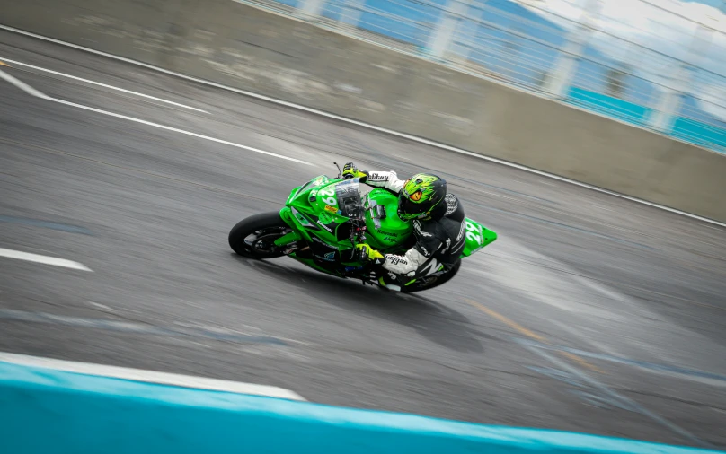 a person on a green motorcycle taking a turn
