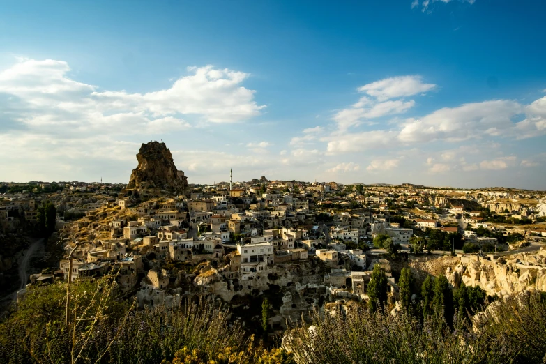 a city is situated among trees and rocky hills