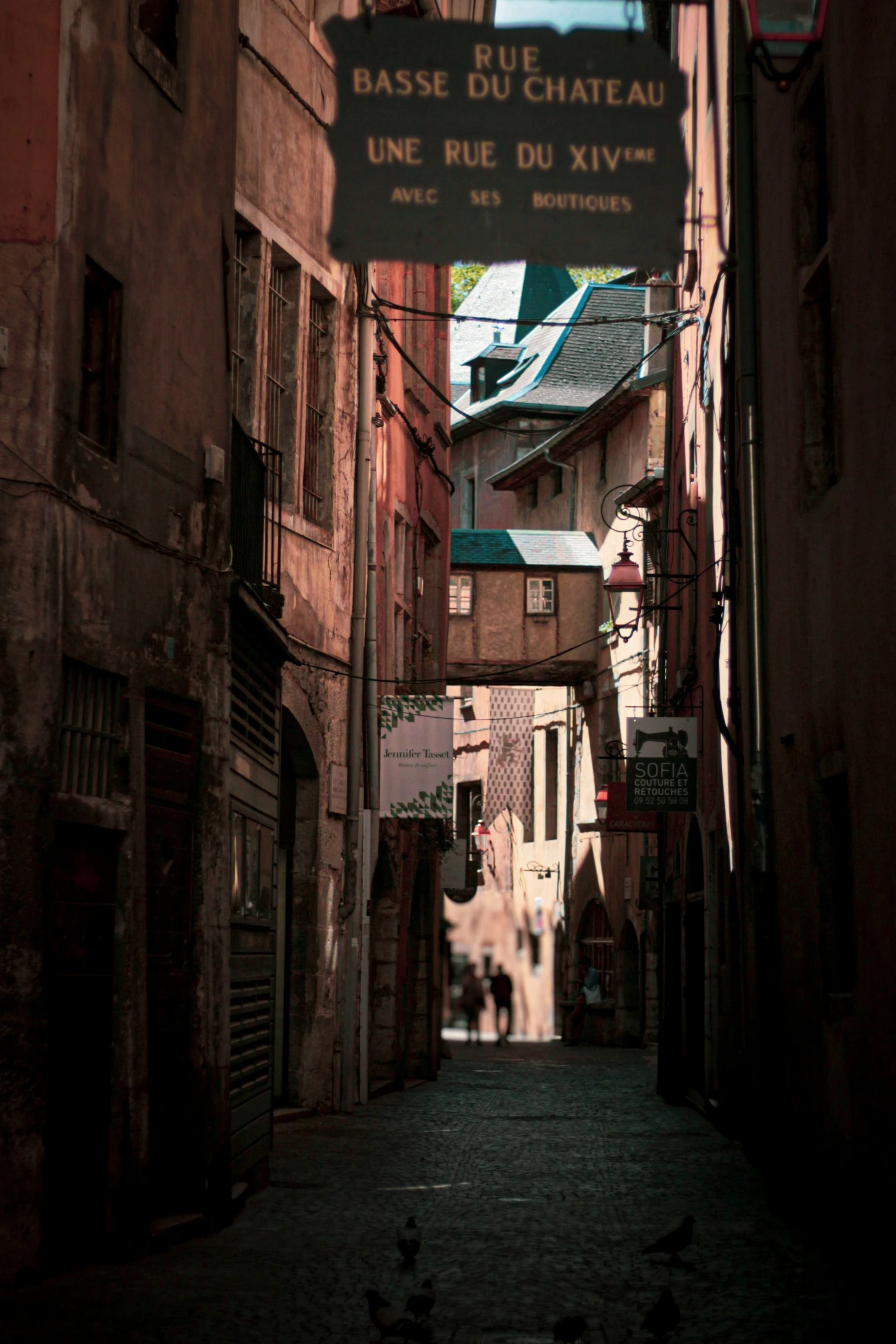 a narrow city street with old buildings and people