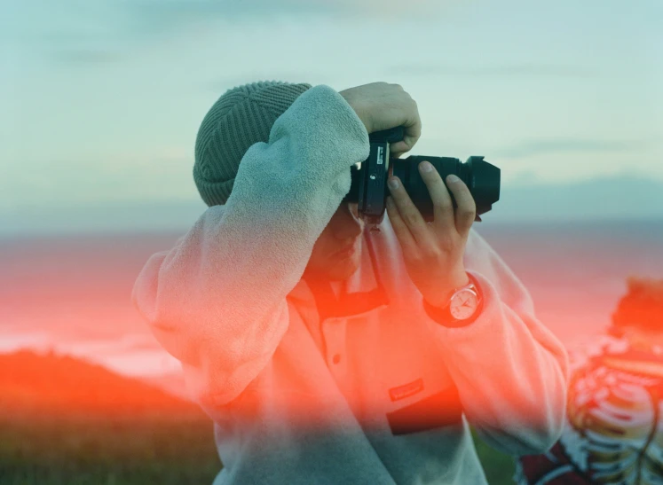 a person with an camera in front of a blurred image