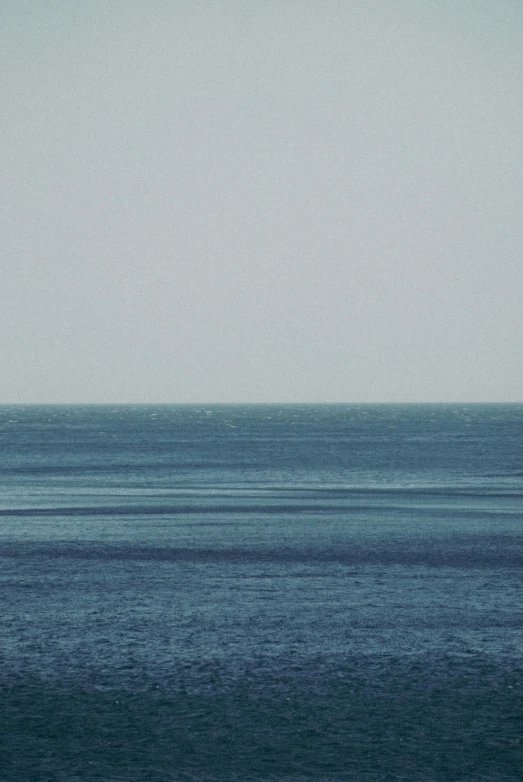 a lone sailboat floating out in the open ocean