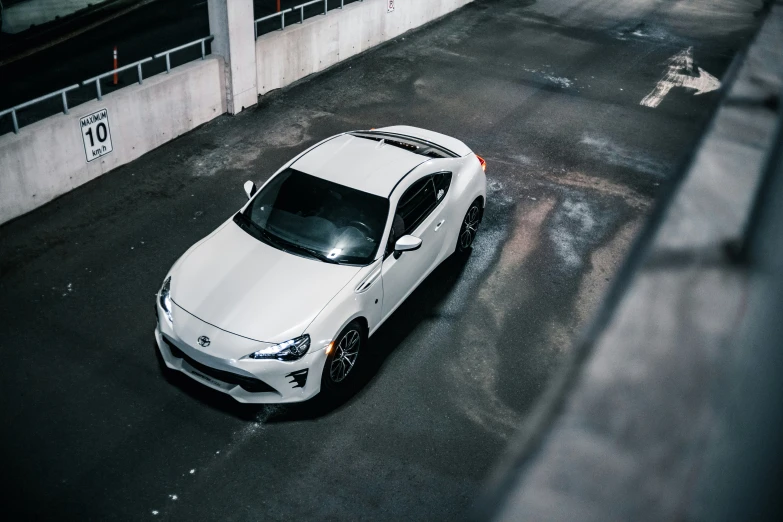 a white sports car parked in an empty lot