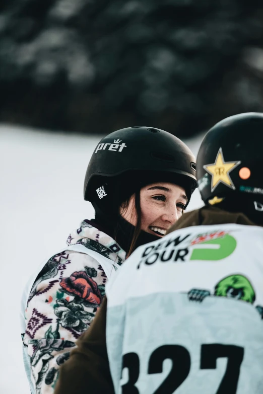 two people with ski gear and one person talking on her phone