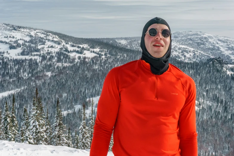 a person in a red jacket standing next to some snow