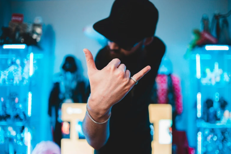 a person standing next to a store holding his hands up