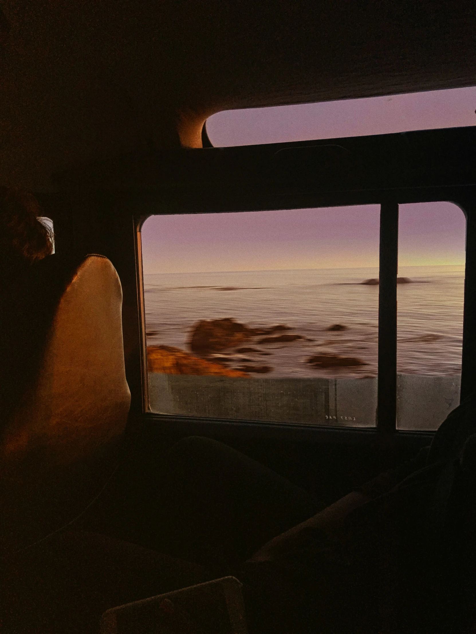 a person looks out of a window at the ocean