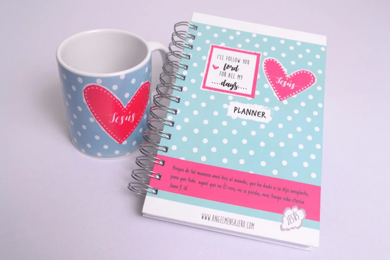 a coffee mug is next to an open planner