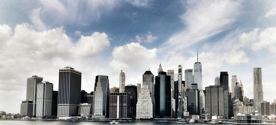 a city from the water with large buildings next to the shore