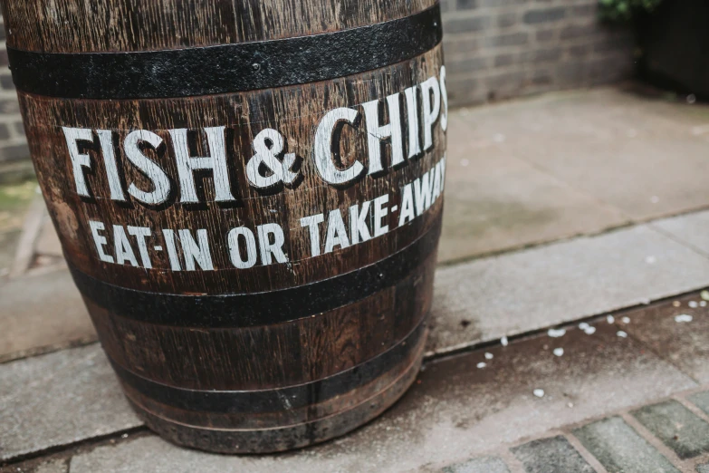 a close up of a wooden barrel with the words fish & chip eat in or take out