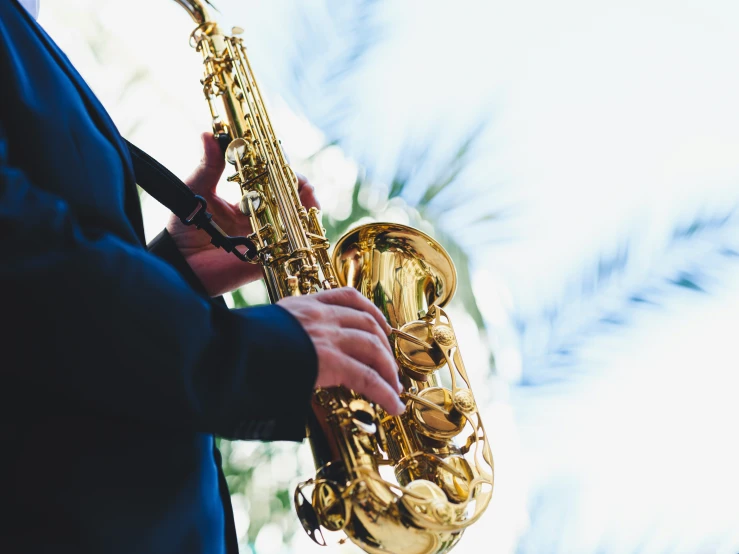 the saxophone player is wearing a blue suit and holding his instrument