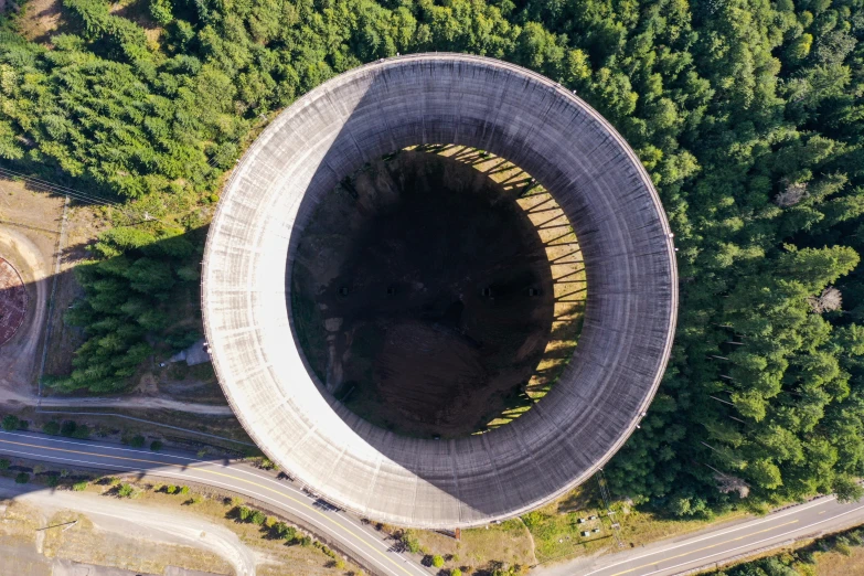 an aerial view of two roads in a tunnel in the middle of a green wooded area