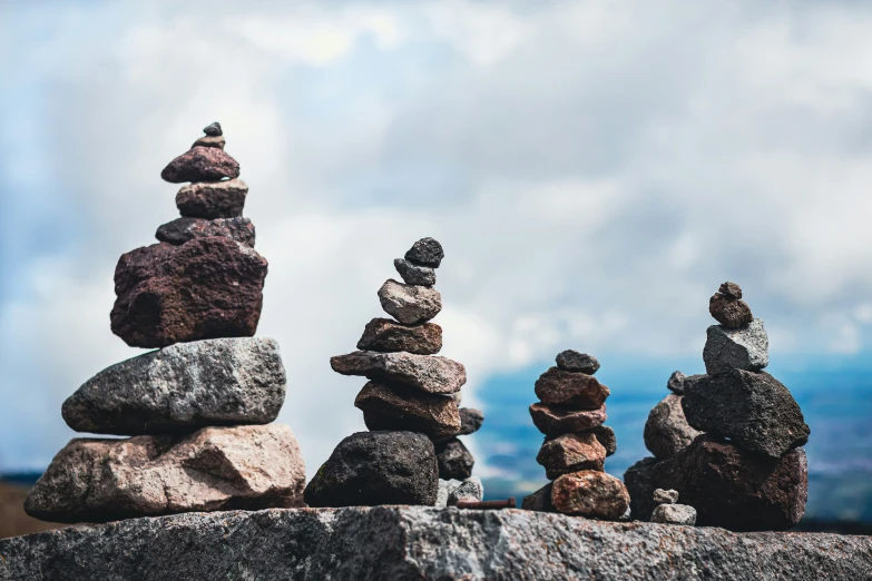 rocks sitting on top of each other with a sky in the background