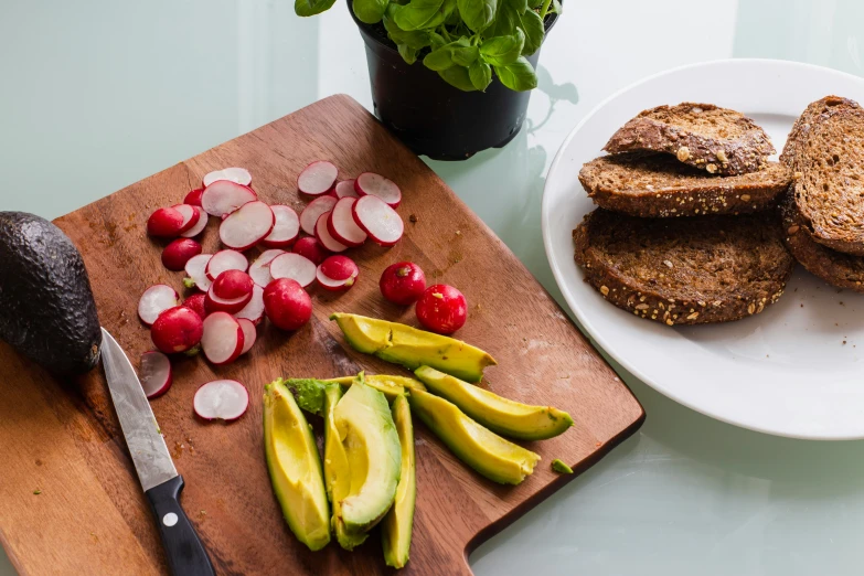 two plates of vegetables with sliced kiwi and radishes