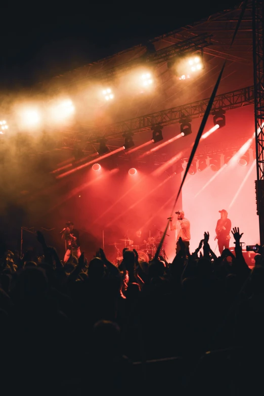 a large group of people at a concert watching a band on stage