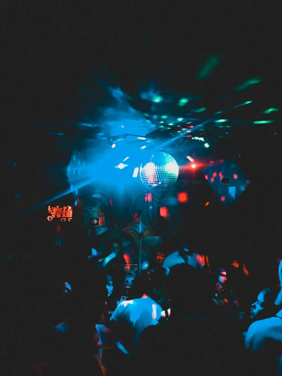 party goers crowding in front of a brightly lit stage