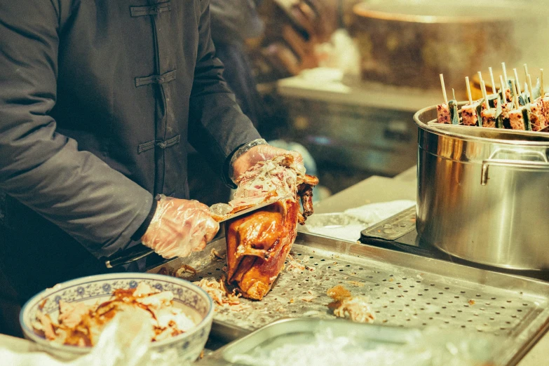 someone preparing meat skewers with toothpicks and sauce