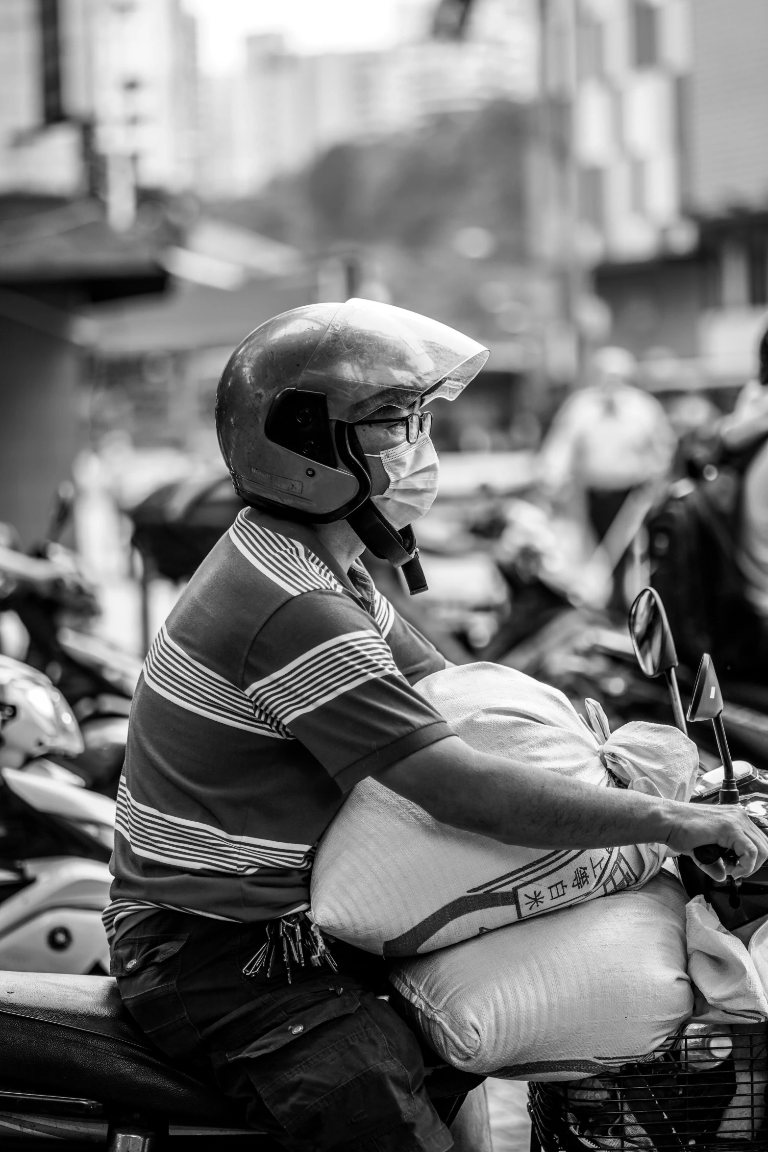 black and white image of a man riding on the back of a motorcycle