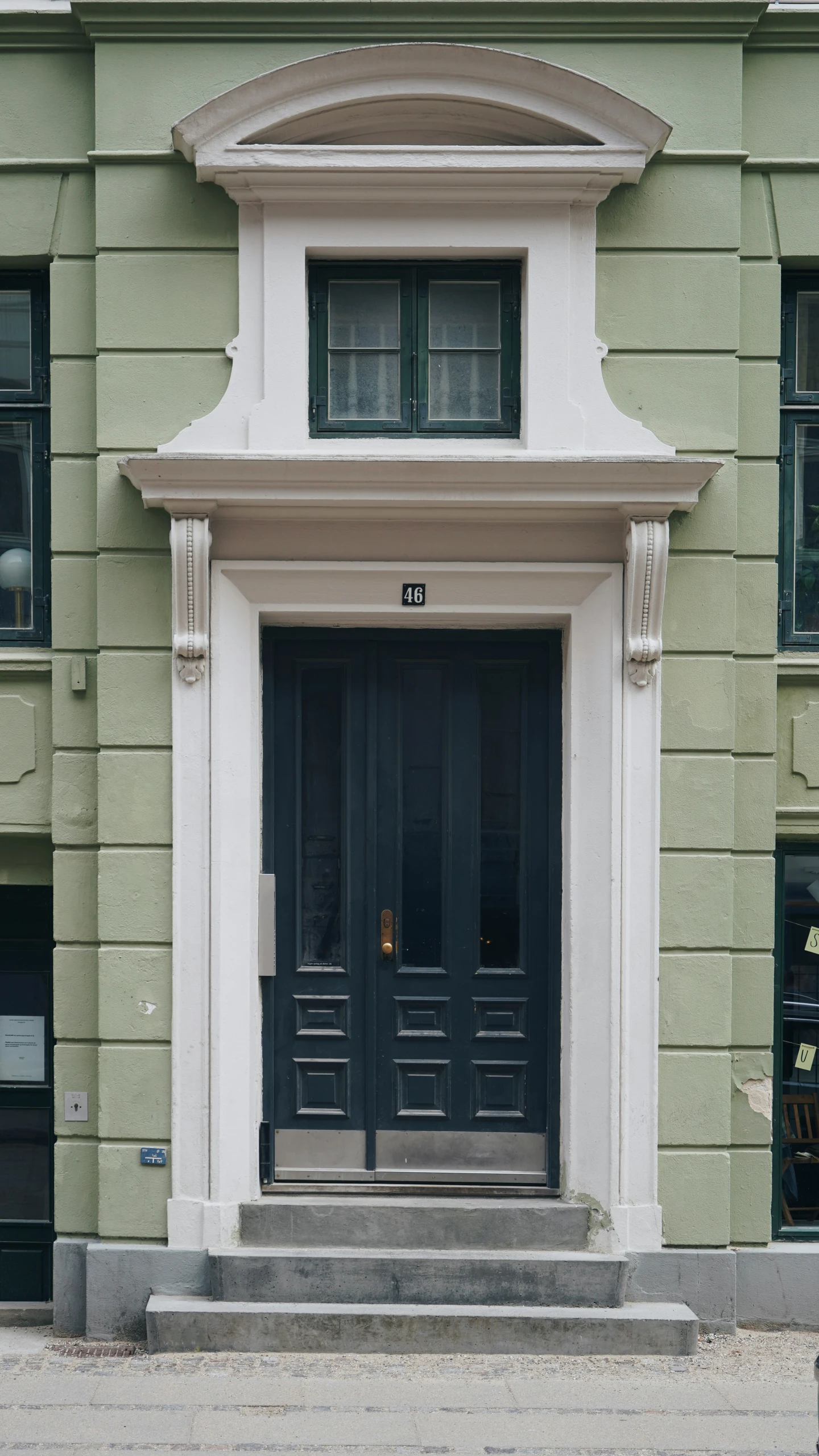 two large doors on a green brick building