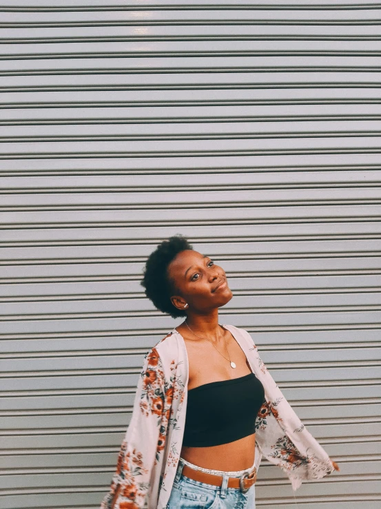 a woman standing next to a wall posing for a picture