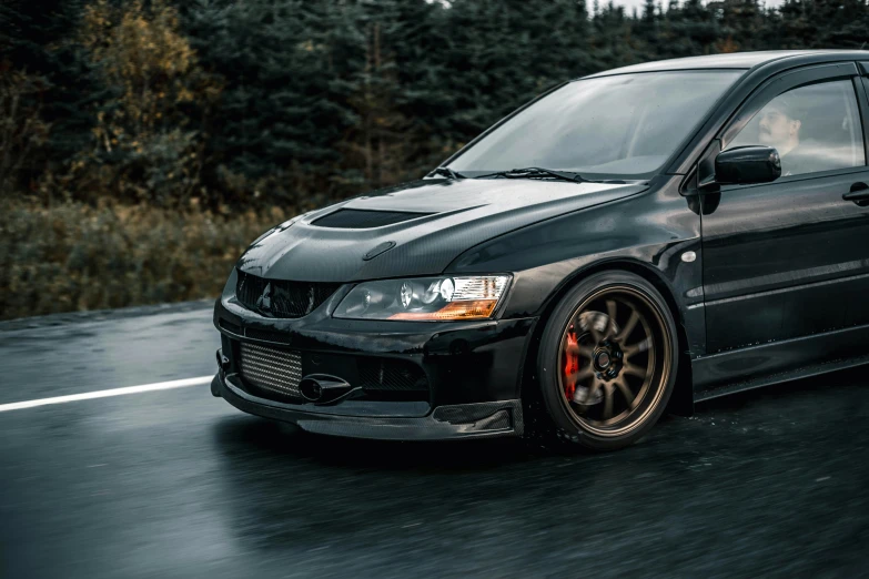 an all - black car with two red wheels is driving down the road