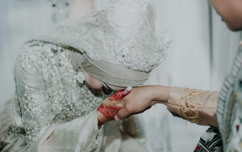 two brides putting together hendals in wedding outfits