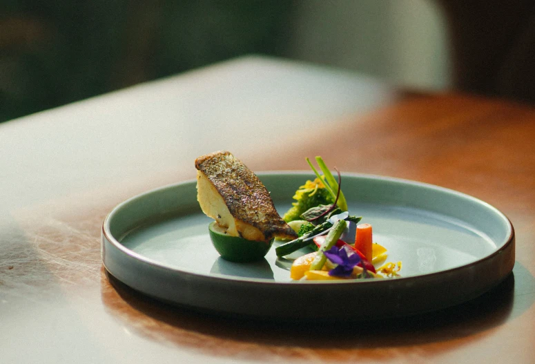 an appetizer dish of fish, asparagus, and flower petals