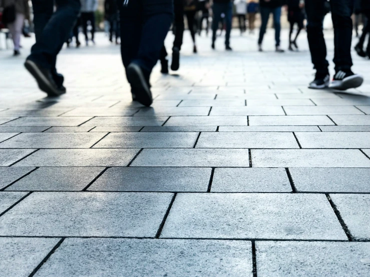 many people are walking down the sidewalk in the city