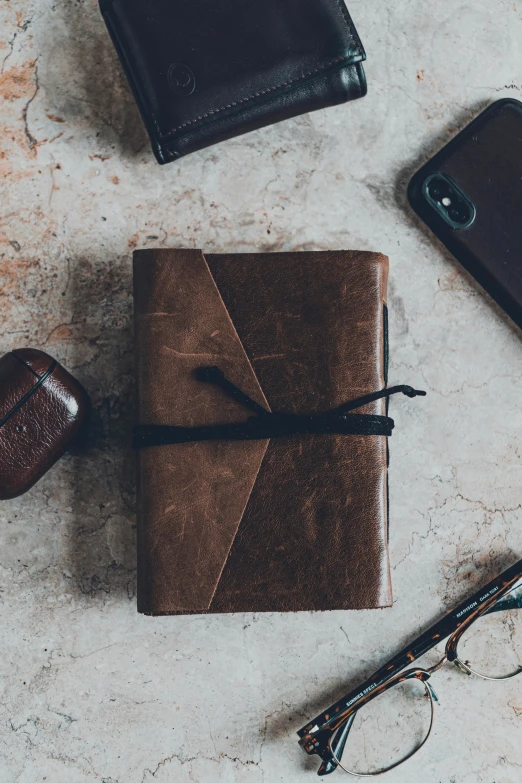 a brown book sits next to a leather case