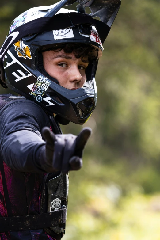 a man with a helmet on giving a thumbs up