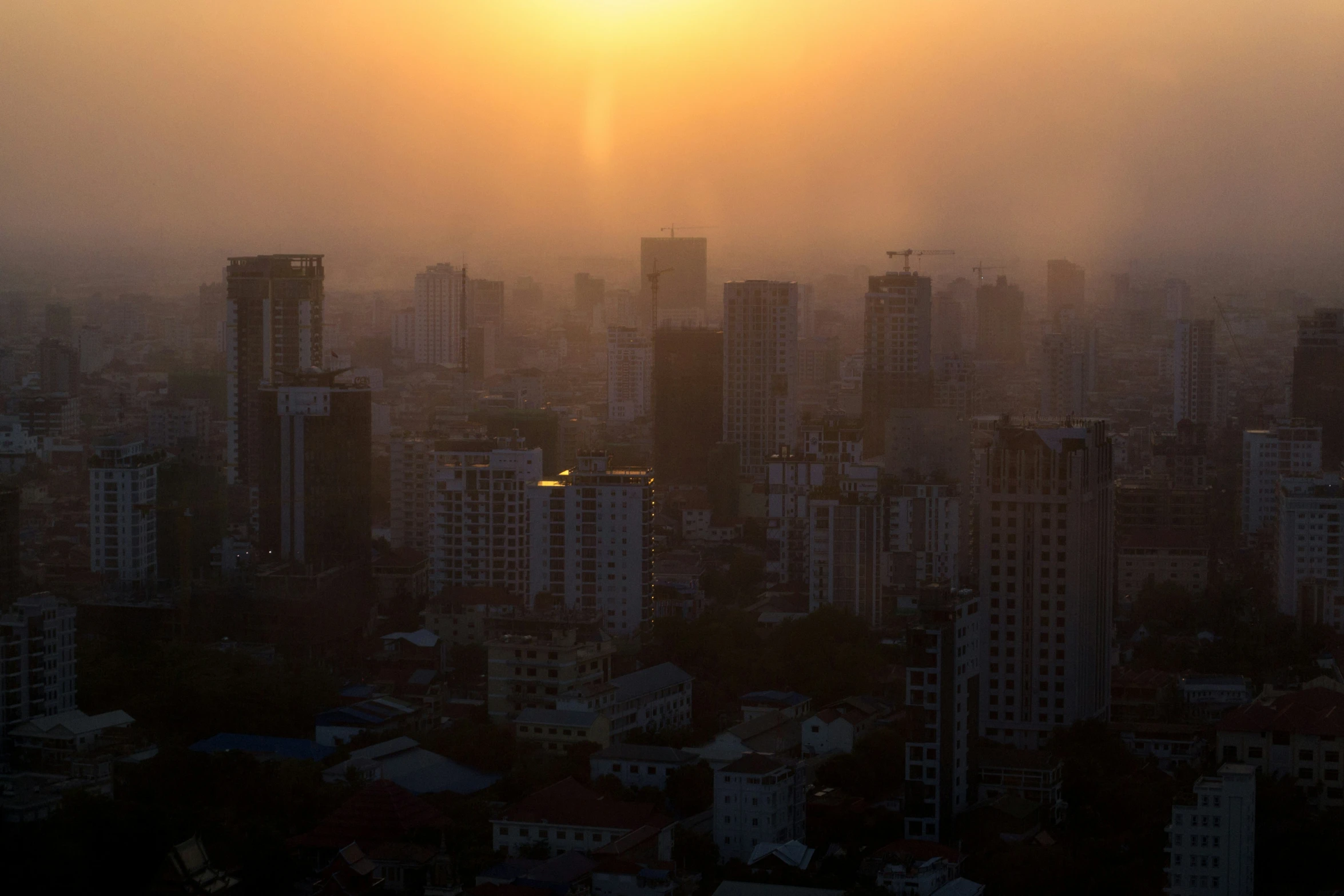 the sun is setting over the skyline of a city