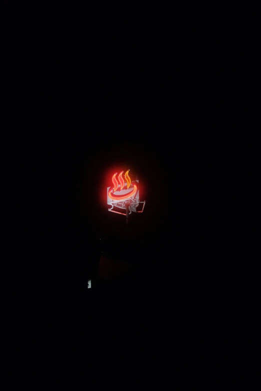 a neon sign with some flames in the dark